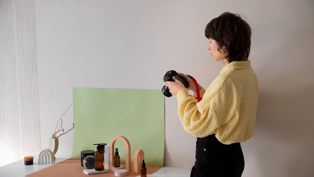 A woman photographs a styled product arrangement